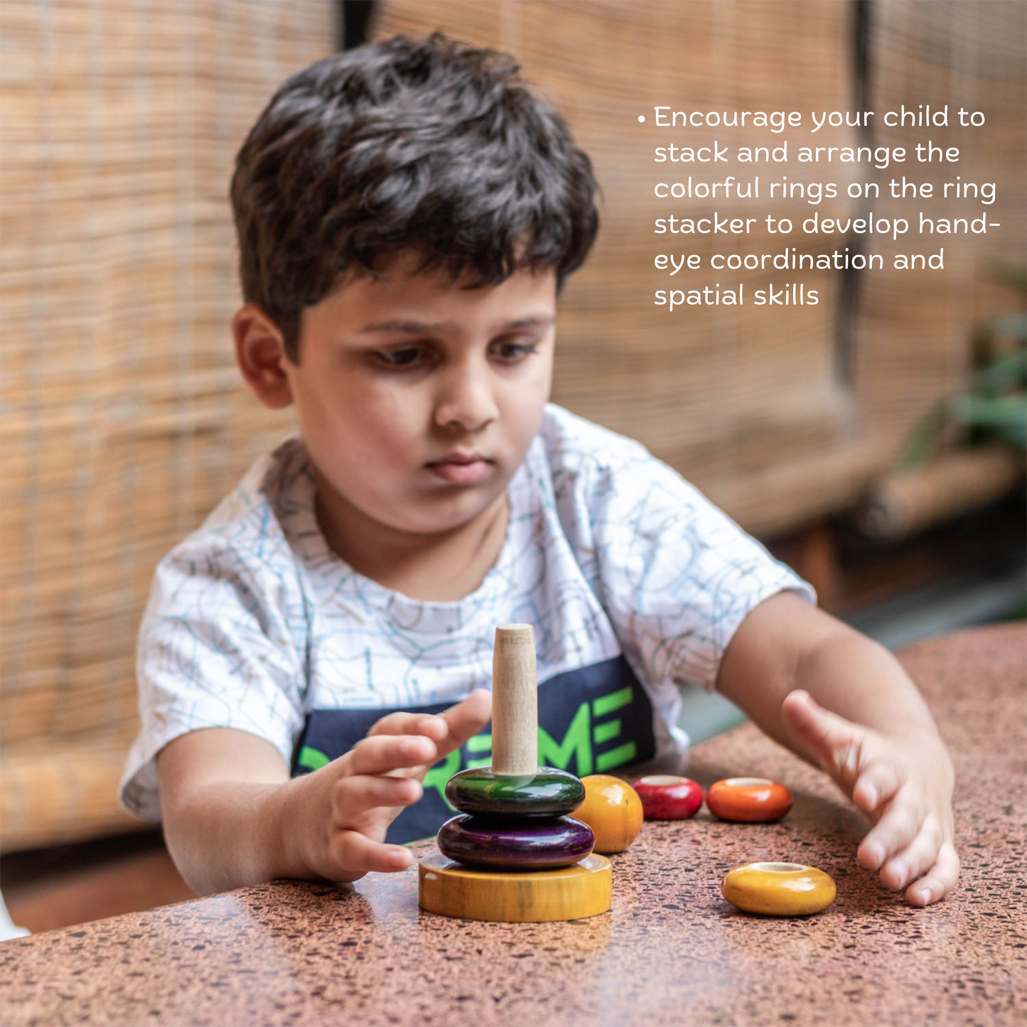 Boy playing with Wooden Ring Stacker from The Toy Trunk – Montessori-inspired handmade wooden toy for kids hand-eye coordination & problem-solving