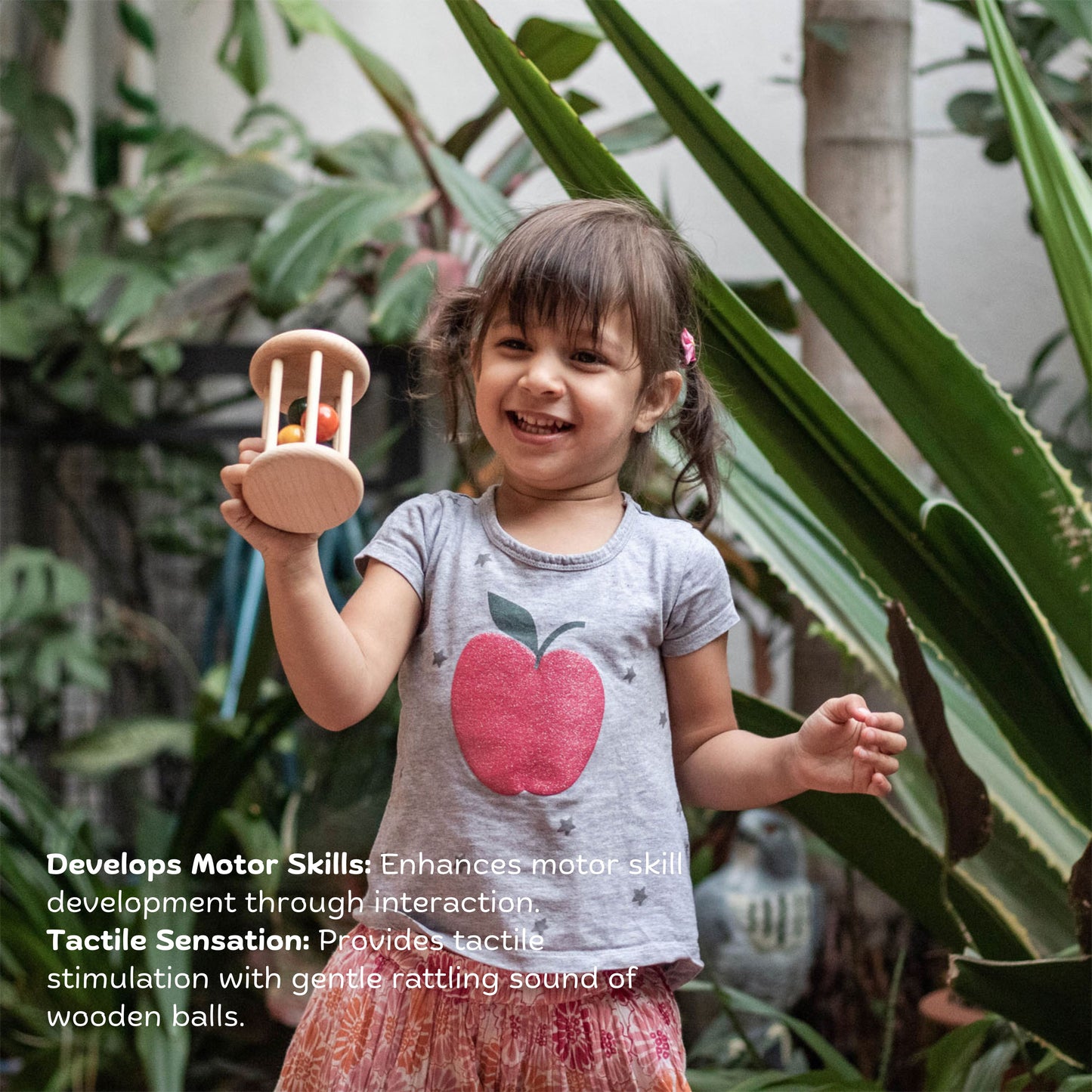 Girl playing with Wooden Rolling Rattle – eco-friendly handmade Montessori wooden toy promoting crawling, movement, tactile stimulation & playful learning