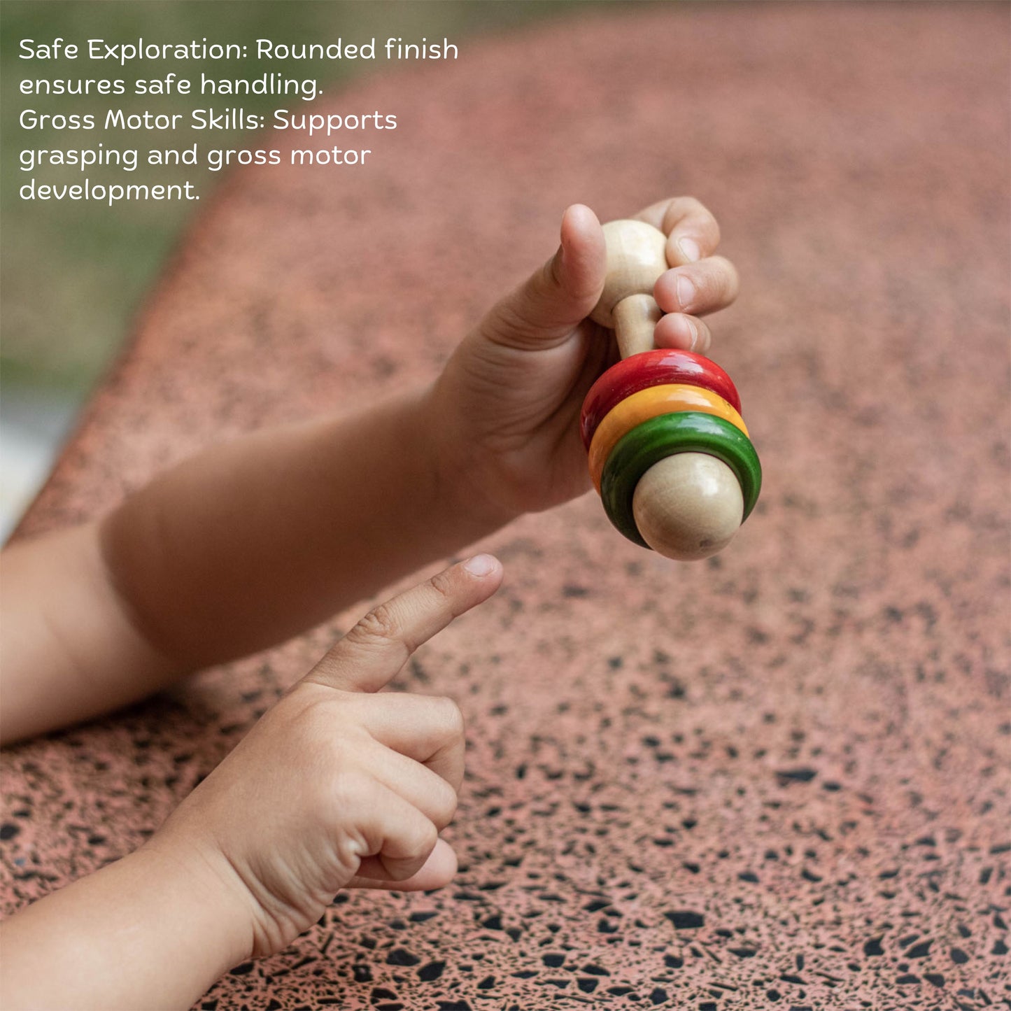 Toddler playing with Wooden Dumbbell Rattle – handmade Montessori wooden sensory toy promoting tactile stimulation, grasping, & motor skills