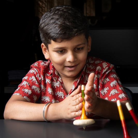 Indian toddler engaged in independent open-ended play with Montessori wooden toys, building creativity, fine motor skills and concentration through screen-free learning