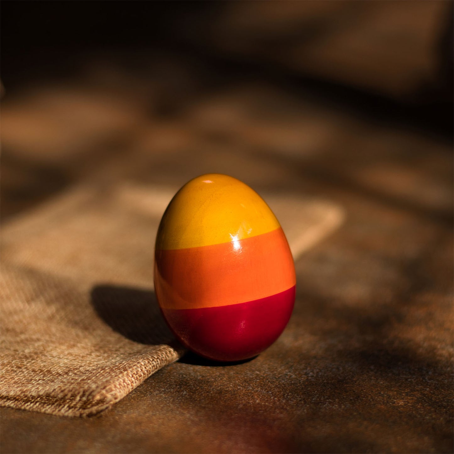 Close-up of Wooden Egg Rattle, handcrafted wooden baby rattle with smooth rounded shape.