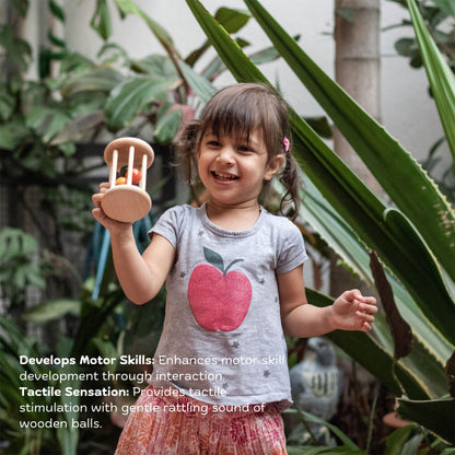 Girl playing with Wooden Rolling Rattle – eco-friendly handmade Montessori wooden toy promoting crawling, movement, tactile stimulation & playful learning
