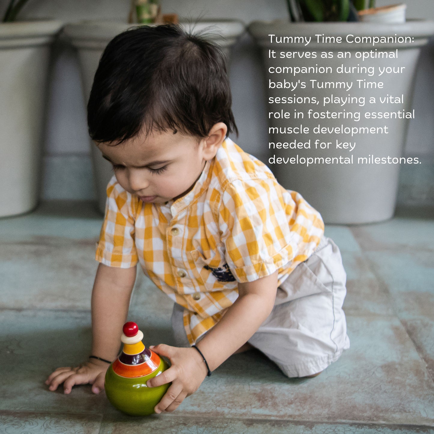 Child playing with Wooden Wobble Rattle Ball for tummy time, crawling and motor skill play.