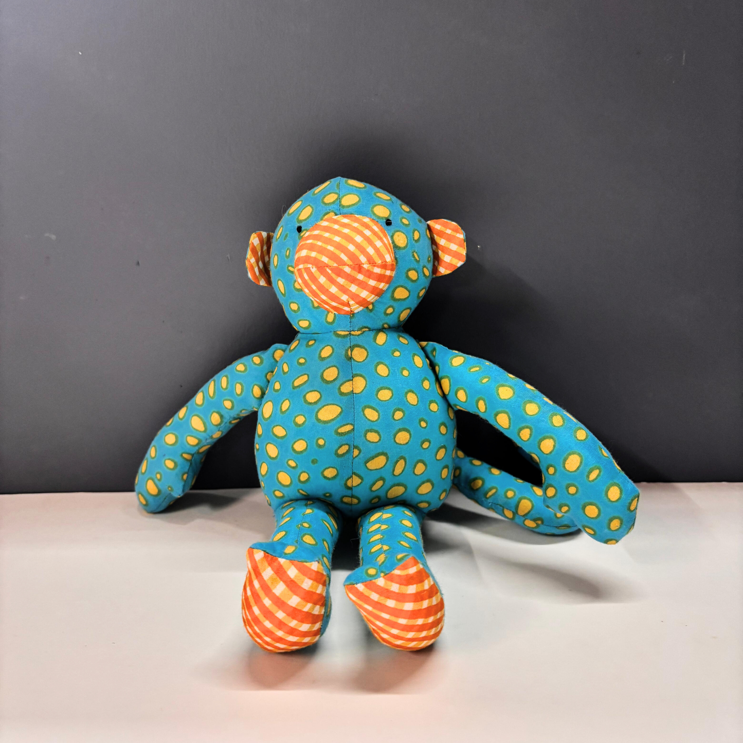Mimi Monkey toddler cuddle toy in teal and yellow spotted handblock-print cotton fabric.
