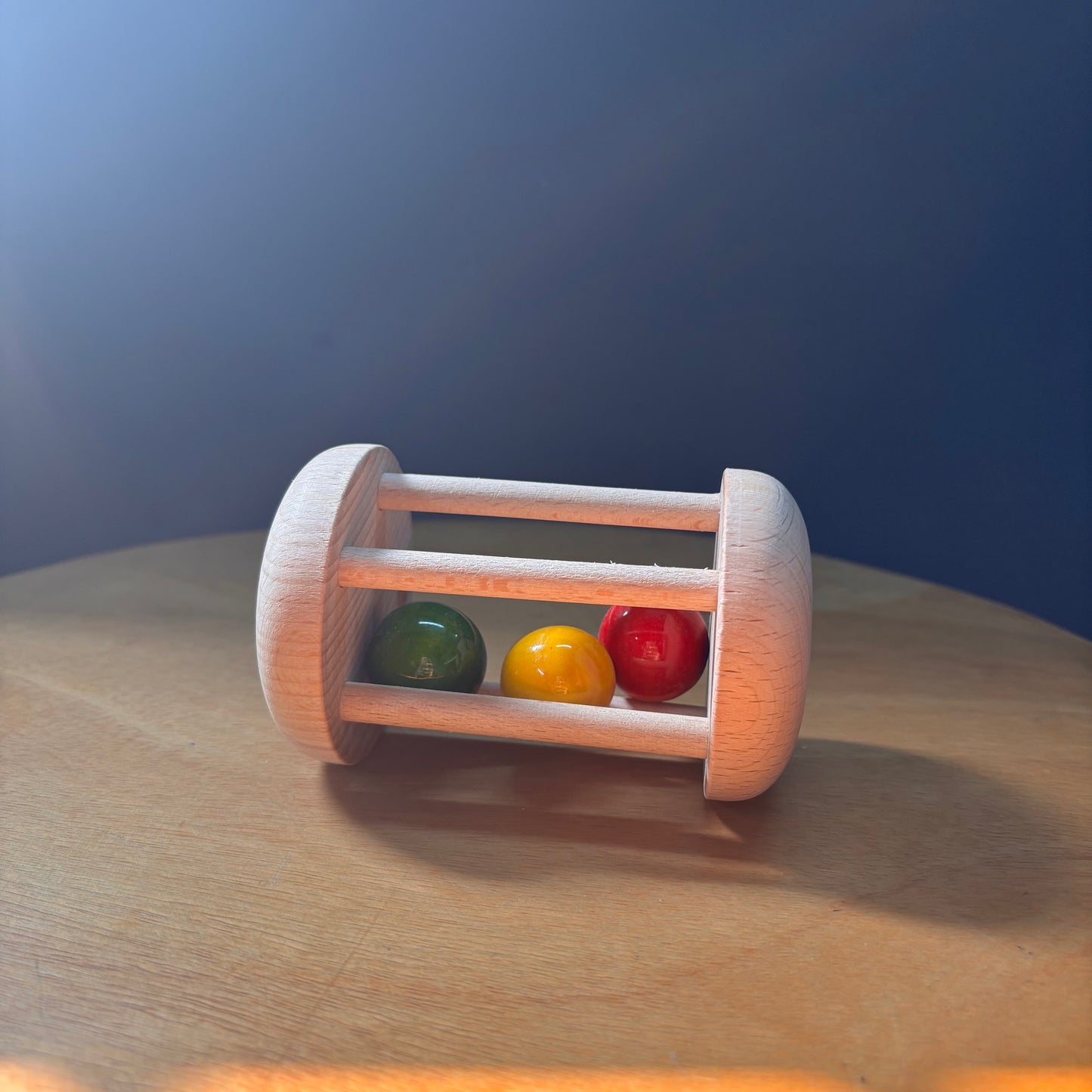 Montessori-inspired wooden rolling rattle for crawling motivation and movement play.