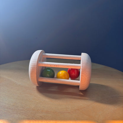Montessori-inspired wooden rolling rattle for crawling motivation and movement play.