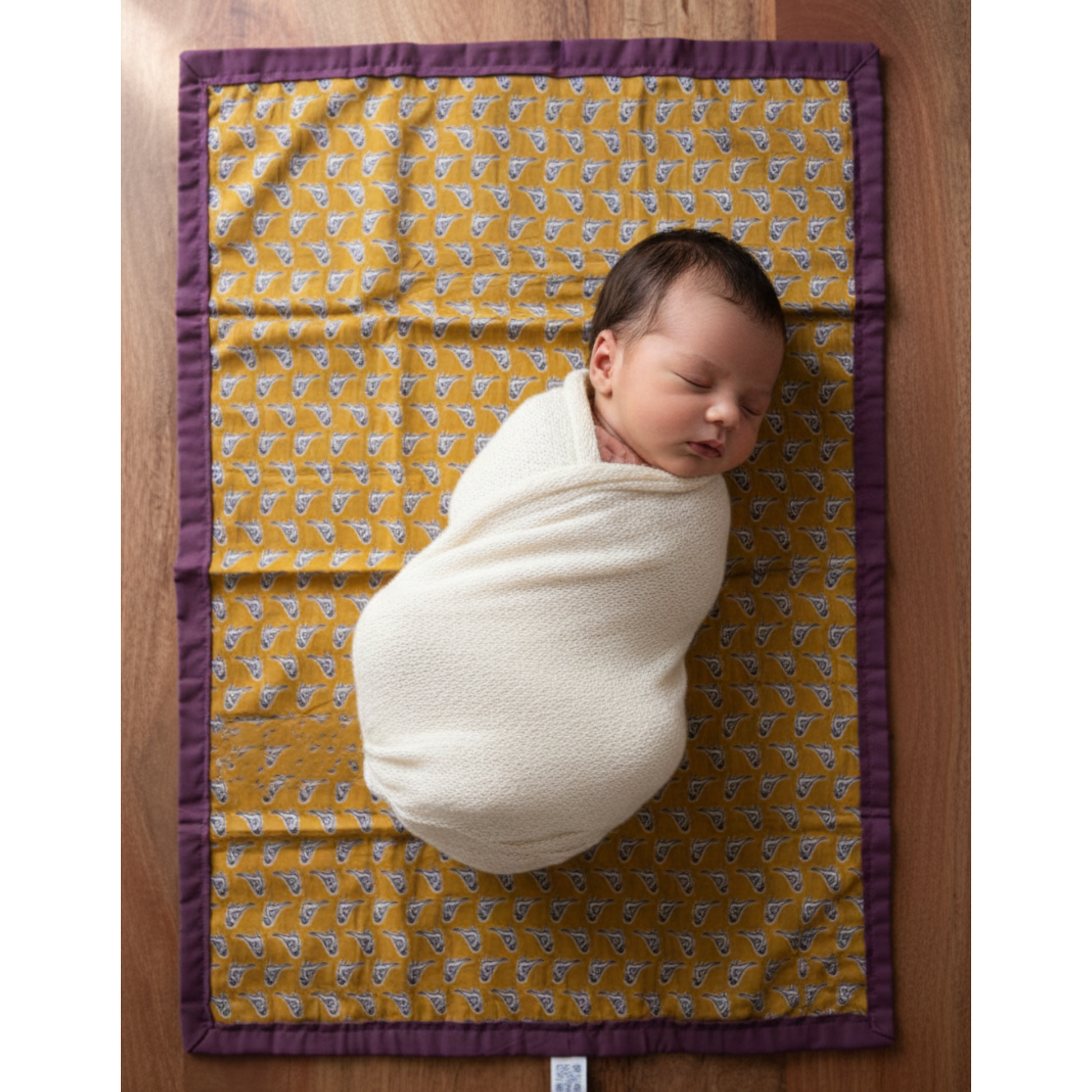 Newborn baby resting on cotton mat from Newborn Baby Gift Set.