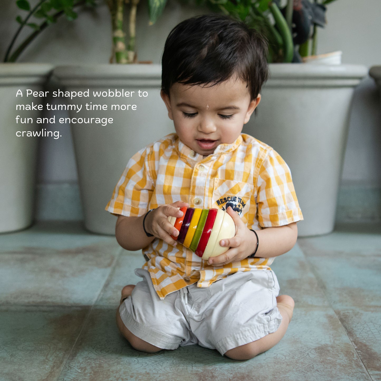 Wooden pear wobbler for babies supporting movement, reaching and tummy time play.