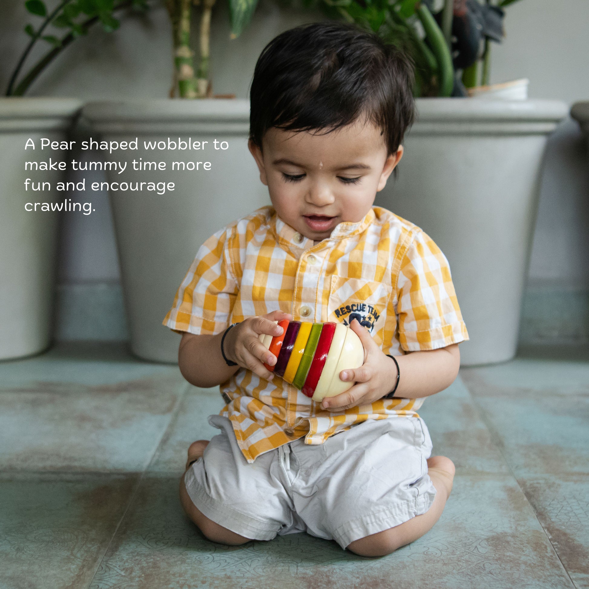 Wooden pear wobbler for babies supporting movement, reaching and tummy time play.