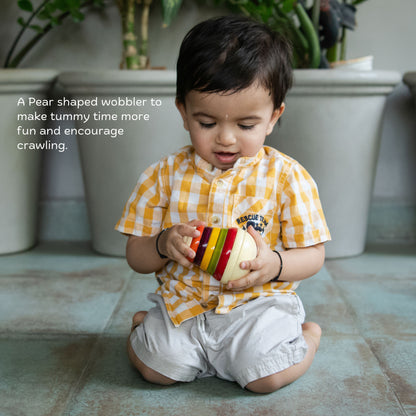 The Toy Trunk Wooden Pear Wobbler toy for toddlers to promote tummy time and crawling