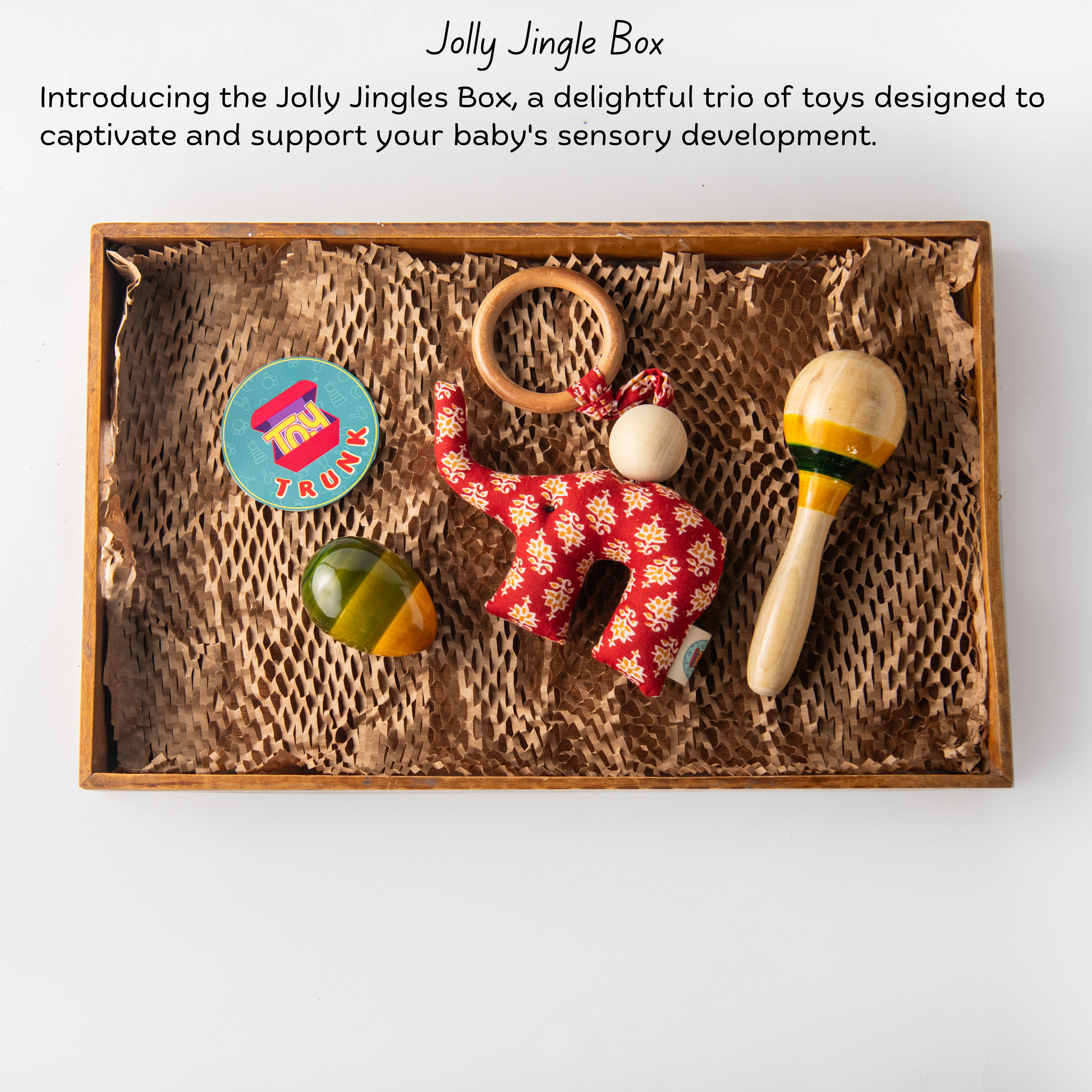 Wooden Jolly Jingle Box The Toy Trunk – product information with maraca rattle, egg rattle, and fabric elephant toy
