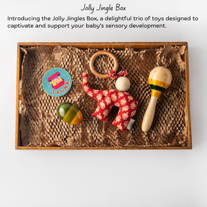 Wooden Jolly Jingle Box The Toy Trunk – product information with maraca rattle, egg rattle, and fabric elephant toy
