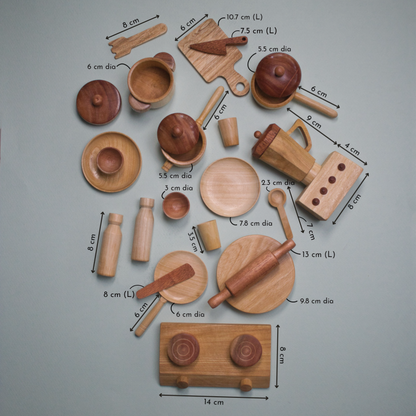 Top-down view of a wooden toy kitchen set with labeled measurements for pots, pans, utensils, and a stove.